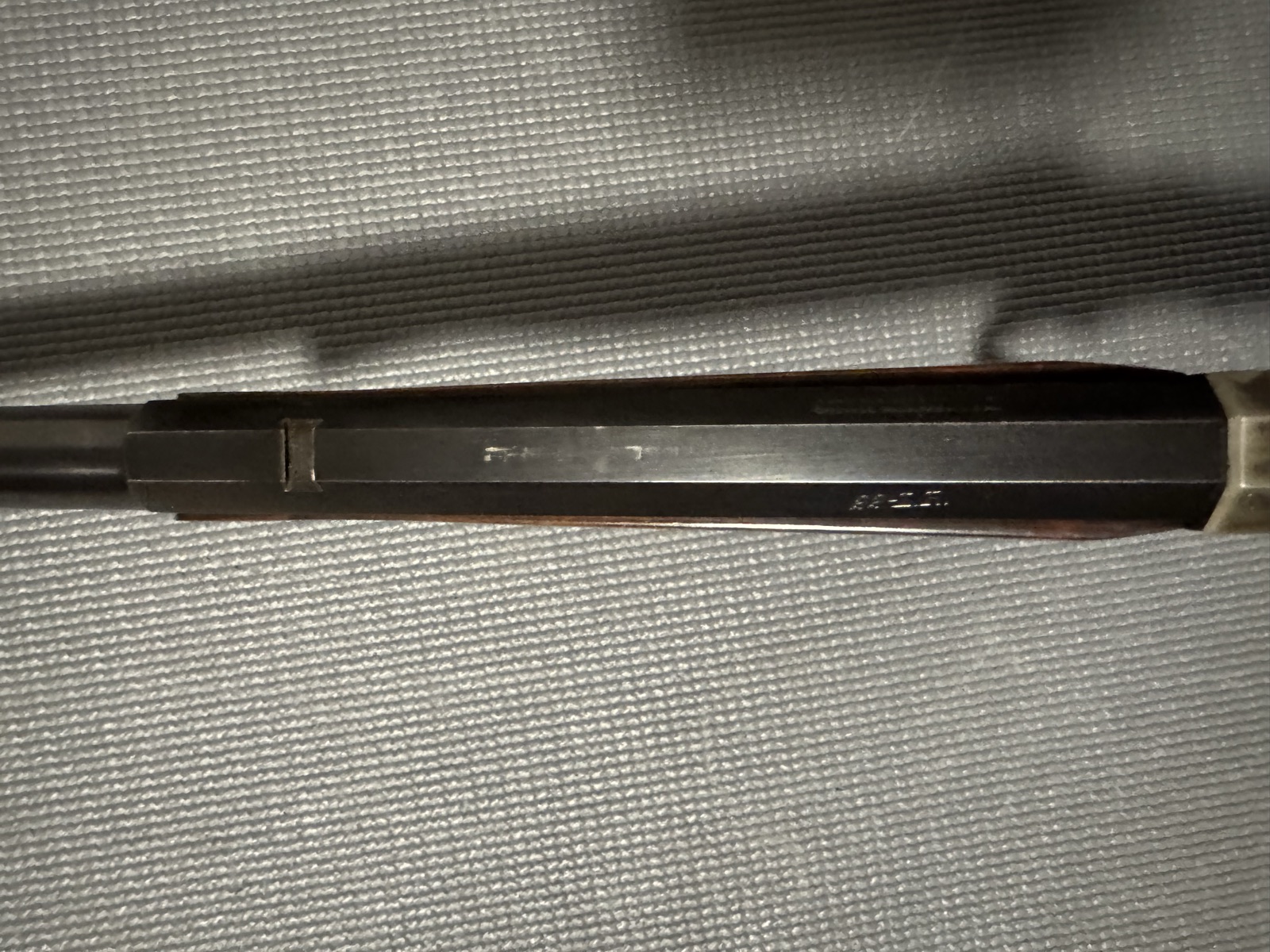 Top flat of the Stevens 44 octagon barrel showing the .22 L.R. caliber stamp and a filled rear-sight dovetail